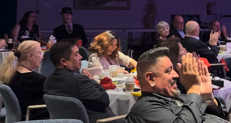 A banquet audience applauding a stage performance